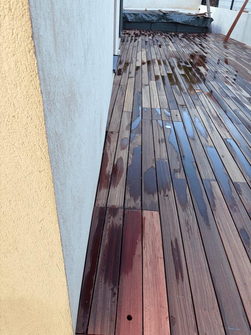 Application d'un saturateur sur les lames d'une terrasse bois pour raviver la teinte