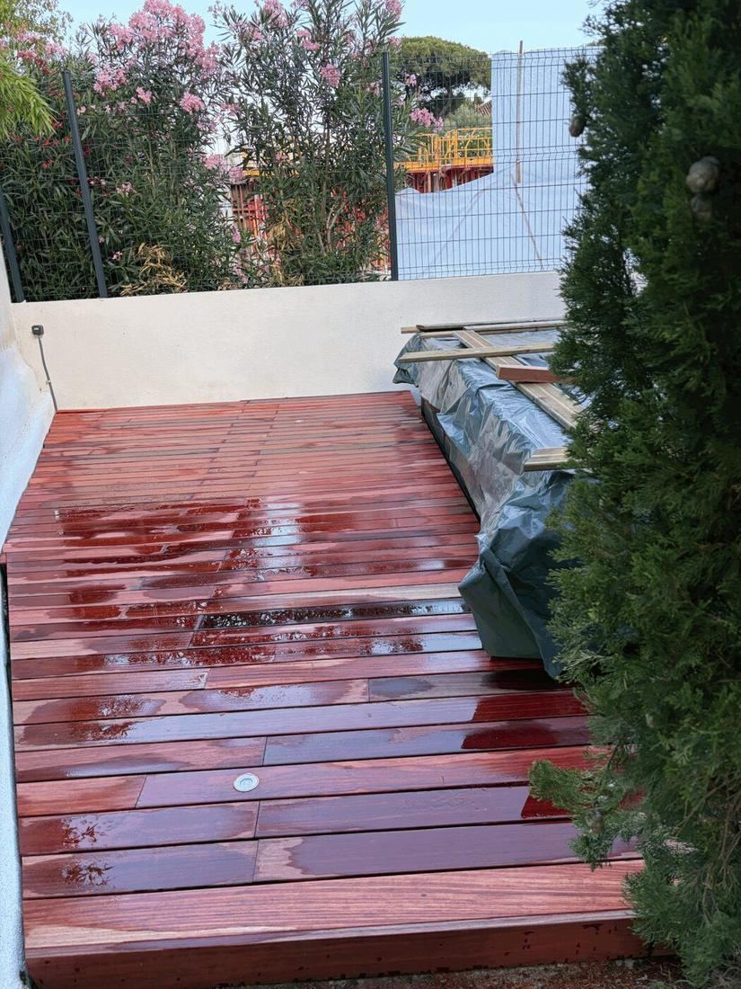 Terrasse bois terminée bordée de végétation et de fleurs