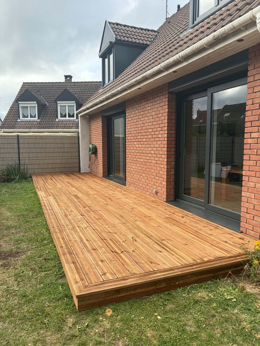 Terrasse en pin classe 4 sur plots posée le long d'une façade en brique à Tourcoing